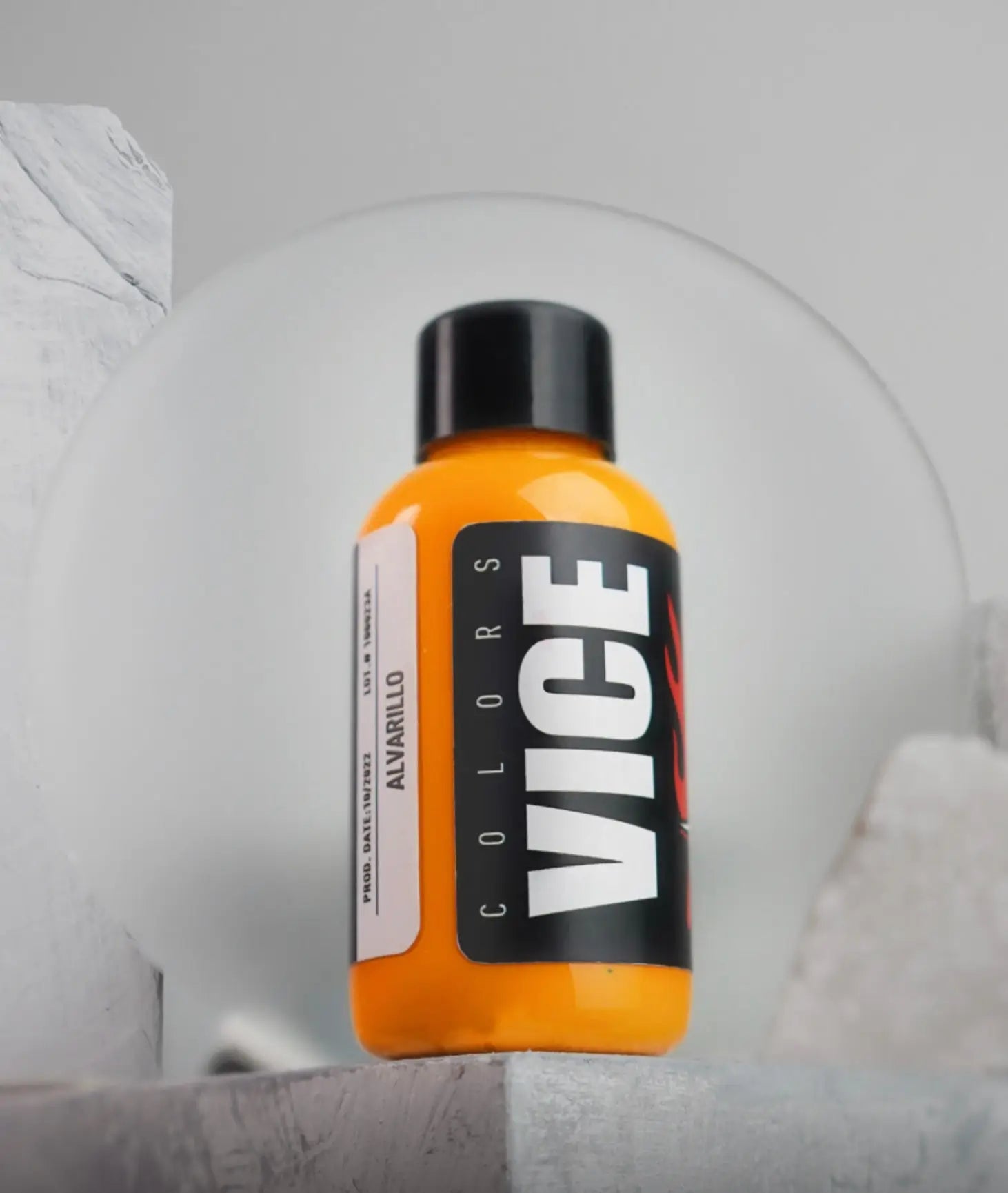 A vibrant orange liquid-filled vice alvarillo bottle with a black cap and bold white vice colors branding label