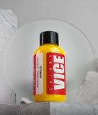 A vibrant yellow plastic bottle of Vice colors paint with black cap and bold red label titled VICE Amarillo