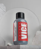 A sleek dark gray bottle of vice colors battleship grey paint with a bold red label and black cap