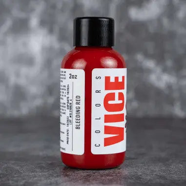 A vibrant red bottle of vice bleeding red paint with a sleek black cap and bold white vice labeling