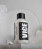 White plastic bottle with black cap featuring bold vice colors label and product name el gato blanco