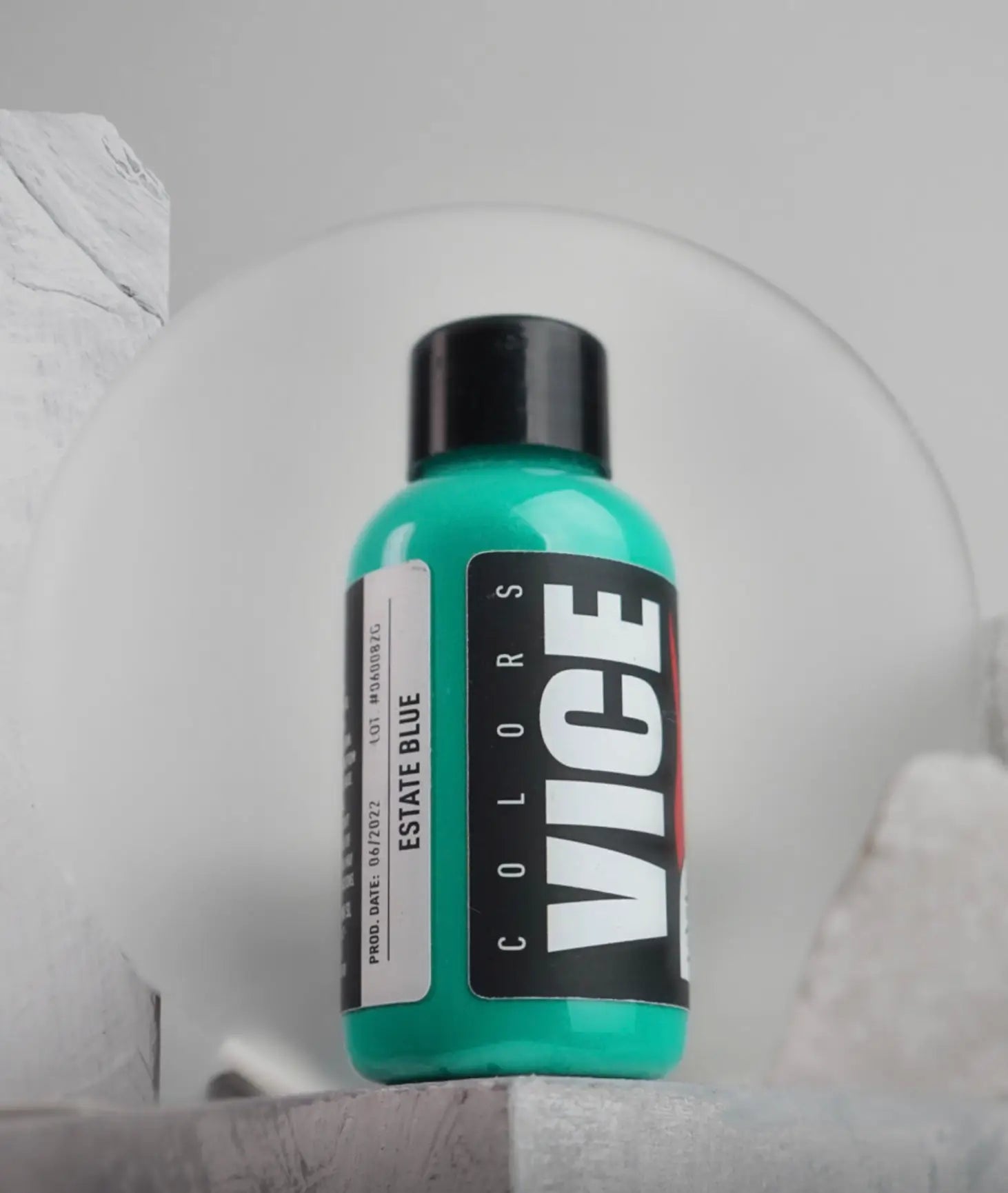 A vibrant teal vice colors paint bottle with a sleek black cap labeled estate blue for artistic use