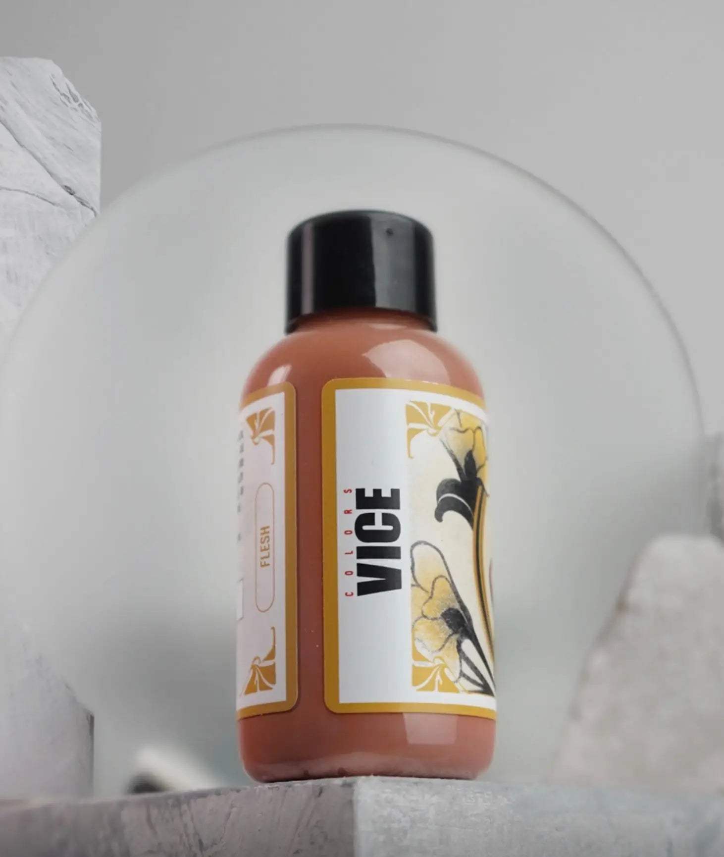 A sleek amber-colored bottle of Vice colors flesh nail polish with black cap and floral ornate label from Daniels Bauti Set