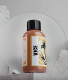 A sleek amber-colored bottle of Vice colors flesh nail polish with black cap and floral ornate label from Daniels Bauti Set