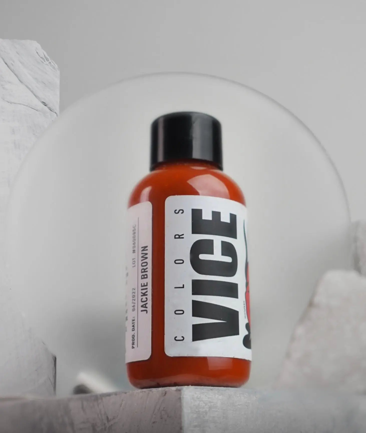 A vibrant orange liquid-filled vice colors bottle with black cap and white label labeled jackie brown