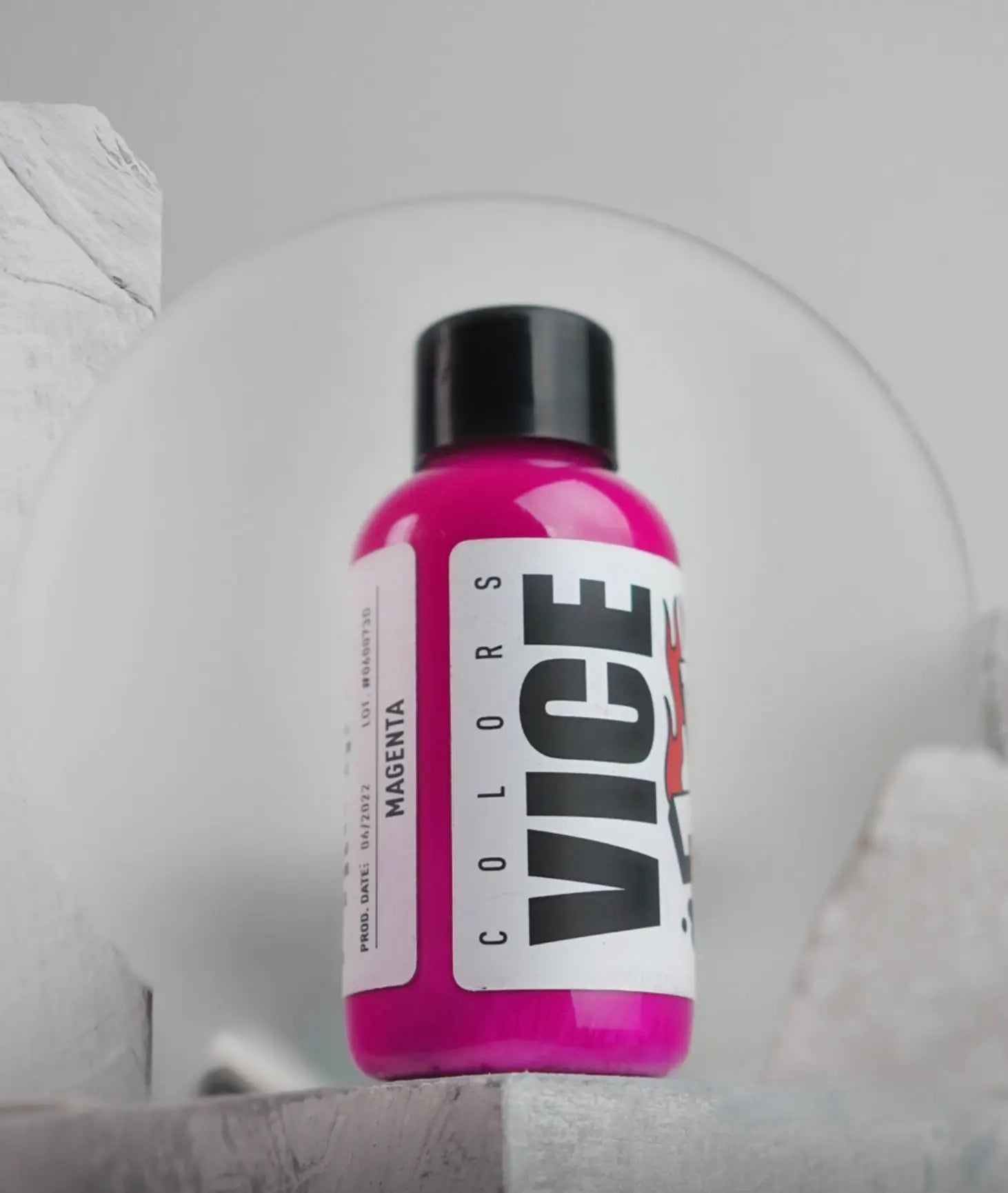A vibrant pink bottle of Vice Magenta acrylic paint with a black cap and white label for creative use