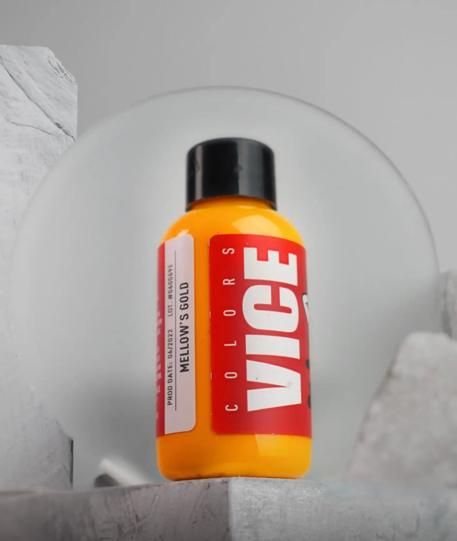 A vibrant orange bottle of vice colors mellows gold paint with a black cap and bold red label for creative use