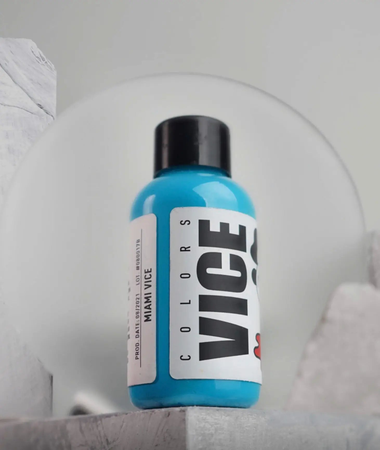 A vibrant blue plastic bottle with a black cap and white vice colors label in the vice miami vice product line