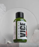 A sleek green glass bottle with black cap and white vice label reading olives matter for premium olive oil