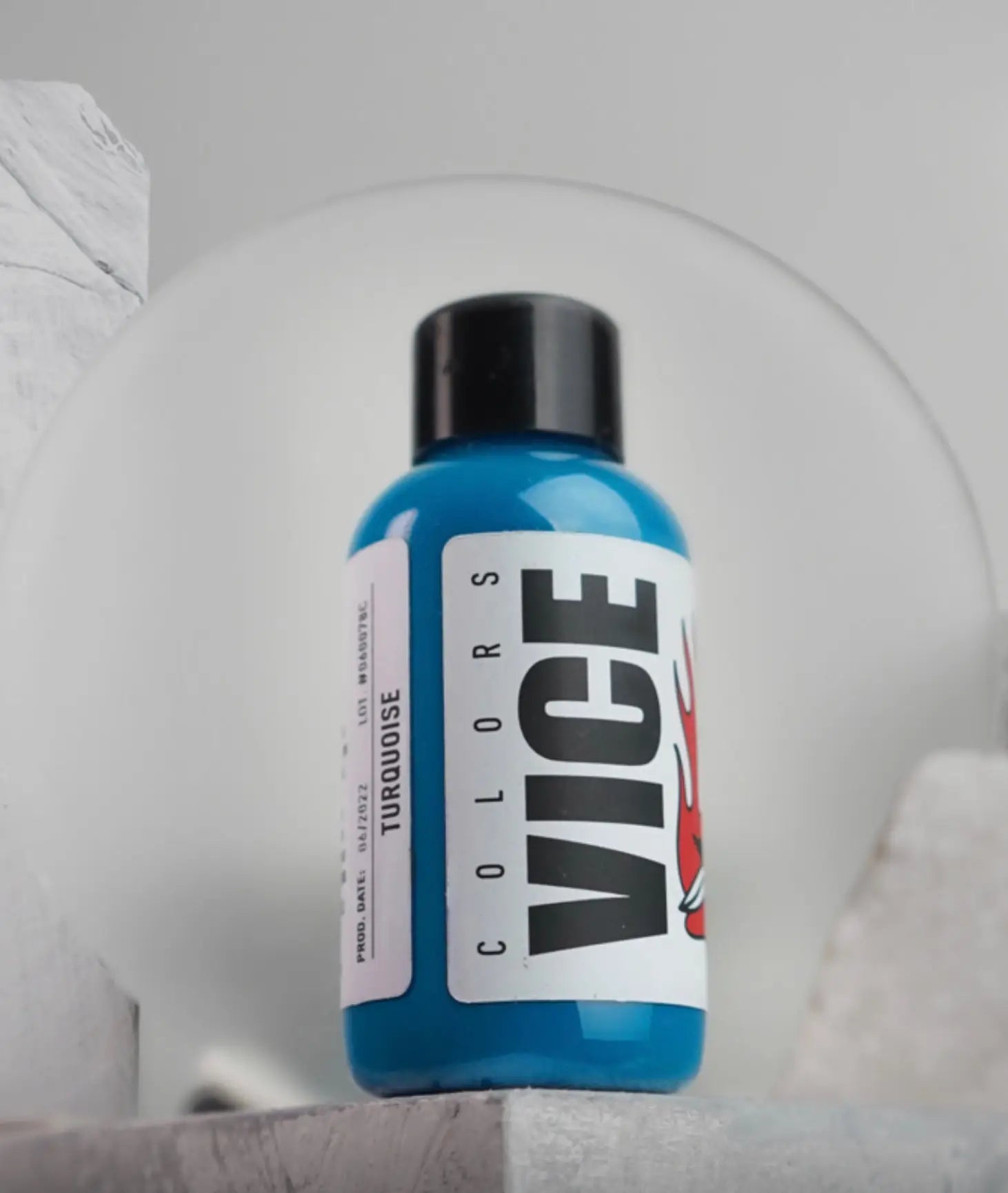 A vibrant blue plastic bottle with black cap and white label featuring bold vice colors branding labeled turquoise