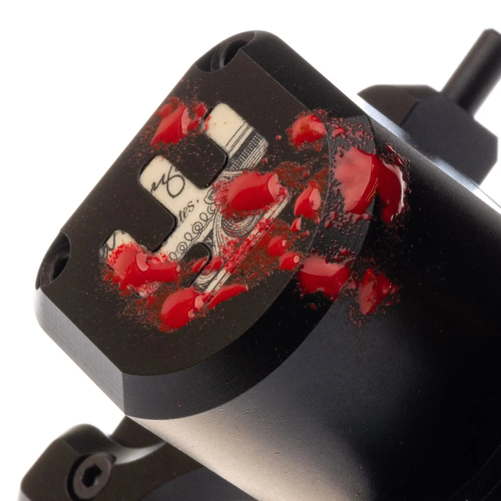 Schwarze Tattoo-Maschine aus Metall vlad blad avenger 2 pro mit roten Farben-Spritzern und eingraviertem Dollar-Schein-Design auf der Oberfläche