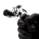 Schwarz-silberne Nickel-Tätowiermaschine VLAD BLAD Avenger 4 Pro mit Swastika-Emblem, gehalten in behandschuhten Händen