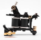 VLAD BLAD Coil Bladder Packer Pro Tattoo-Maschine mit doppelten Spulen, schwarzem und goldfarbenem Metallrahmen und weißen Unterlegscheiben