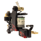 Black Vlad Blad coil tattoo machine with gold accents and red splatter featuring cylindrical reservoir e6083 5 label
