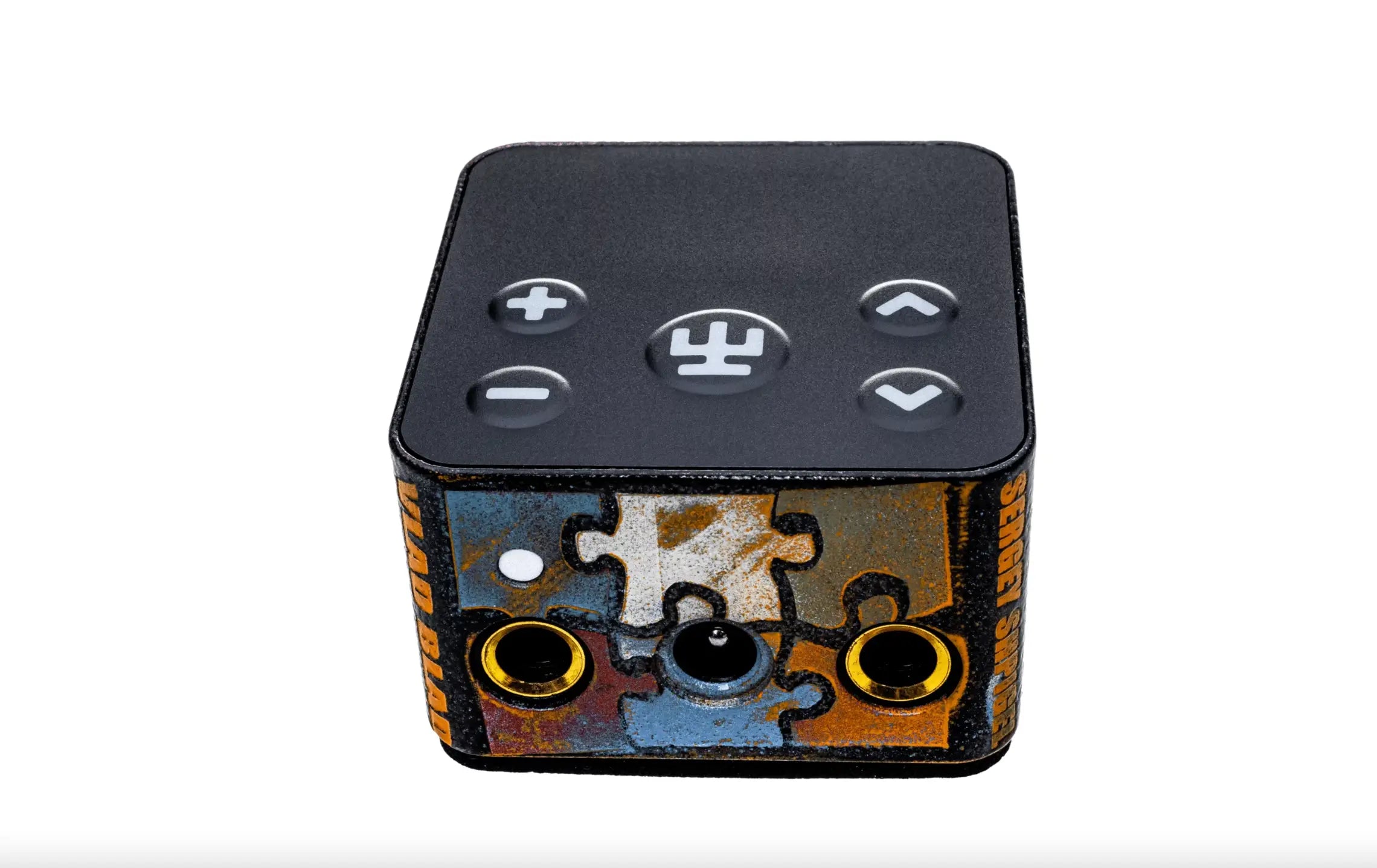 Black cube-shaped VLAD BLAD PowerBox 5 Pro by Sergey Shpigel with puzzle-piece sides, gold audio jacks, and volume control buttons