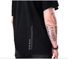 Black short-sleeved cotton vlad blad shirt showing back with vertical white text design
