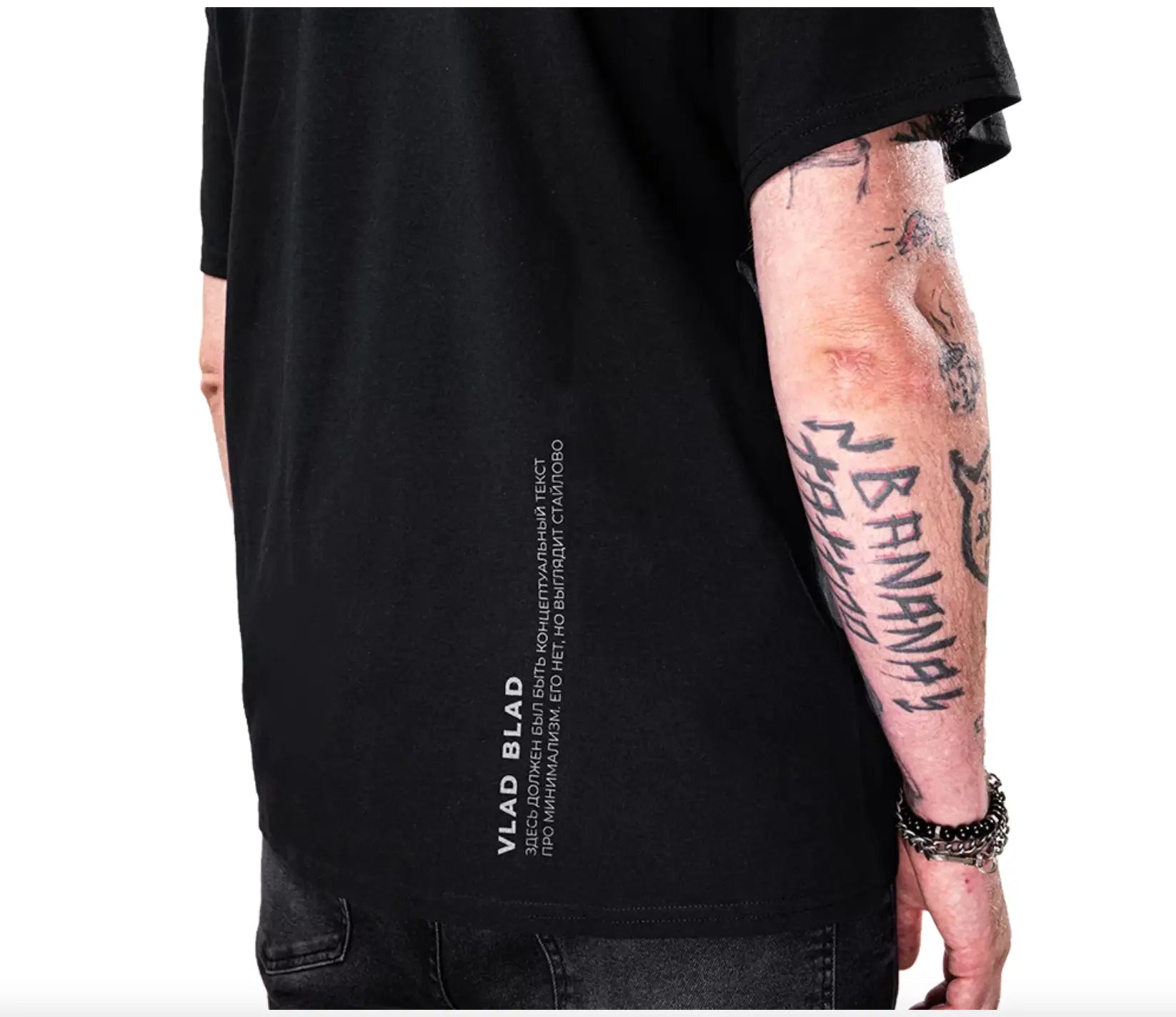 Black short-sleeved cotton vlad blad shirt showing back with vertical white text design