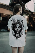 White oversized tee featuring a black ritual skull graphic with flowing hair and wolfpack black ritual text for unisex wear