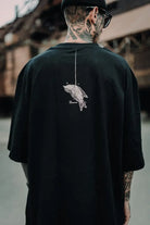Black oversized tee unisex with white line art bird graphic on the back from wolfpack connection collection wears size