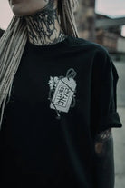 Black oversized tee unisex featuring white line-art japanese talisman graphic with kanji and floral details wears size