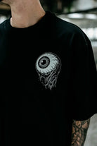 Blackes oversized Unisex-T-Shirt aus Baumwolle mit detailliertem weißem Augapfel-Motiv mit Wurzeln und tropfenden Effekten
