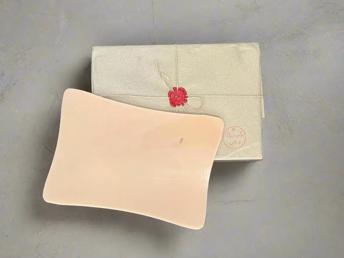 alt
Beige Seifenschale aus Keramik mit sanft geschwungenen Kanten und glatter matter Oberfläche, gezeigt auf holzähnlicher synthetischer Kunsthaut A5 5 mm